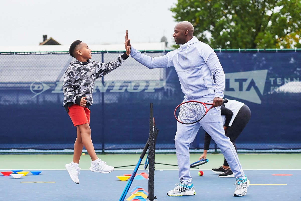 Father and son high fiving over tennis net.jpg