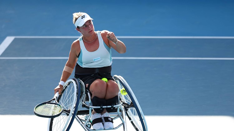 Wheelchair tennis star Lucy Shuker clenching her fist on court while holding her tennis racket