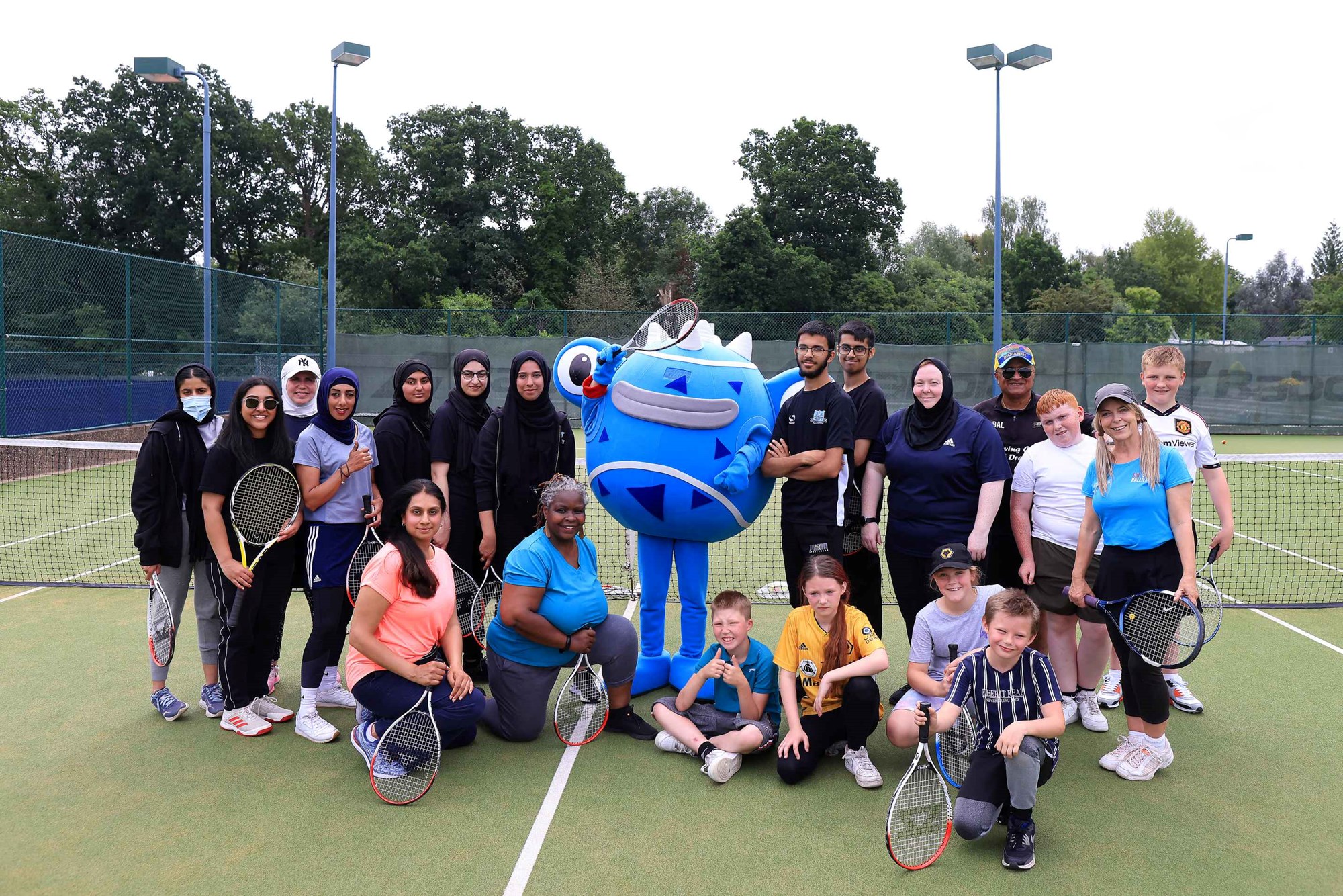 Community groups pictured with the LTA's mascot, one of six Tennisables, on the practice courts at the 2023 Rothesay Classic Birmingham.