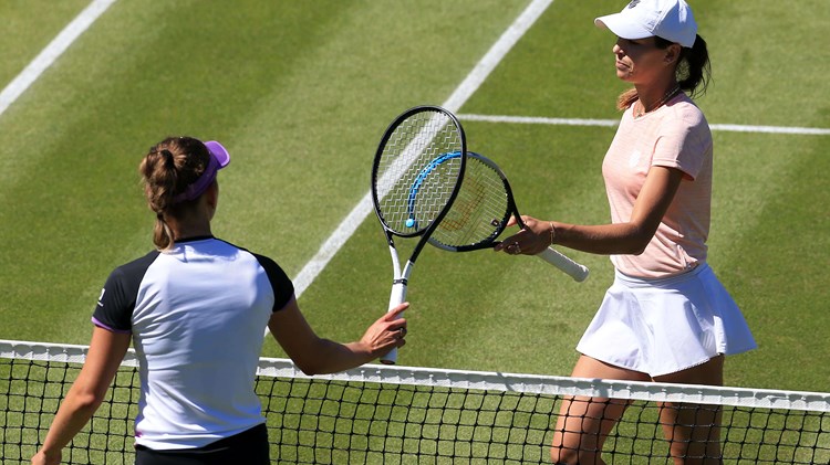 Elise Mertens and Ajla Tomljanović at the tennis net