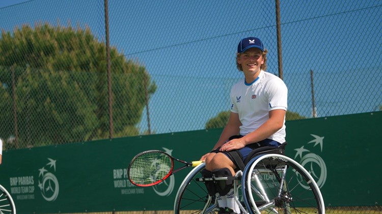 Wheelchair tennis star Ben Bartram sat in his wheelchair on court at the World Team Cup while holding his tennis racket