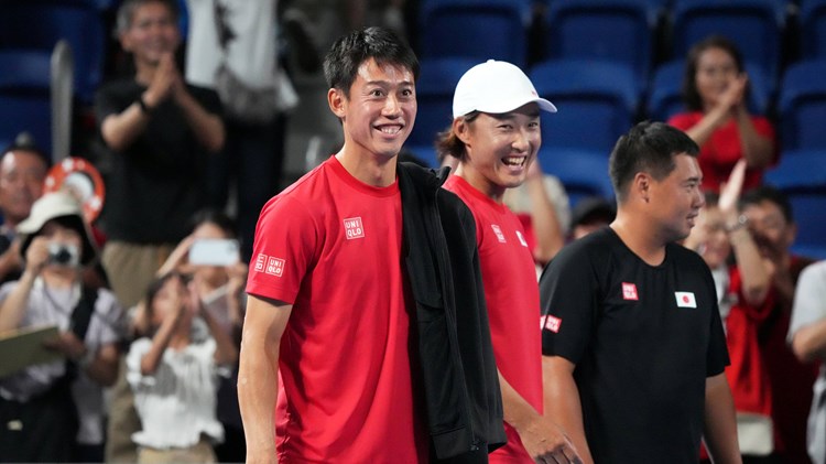 Kei Nishikori smiling on court at the Davis Cup