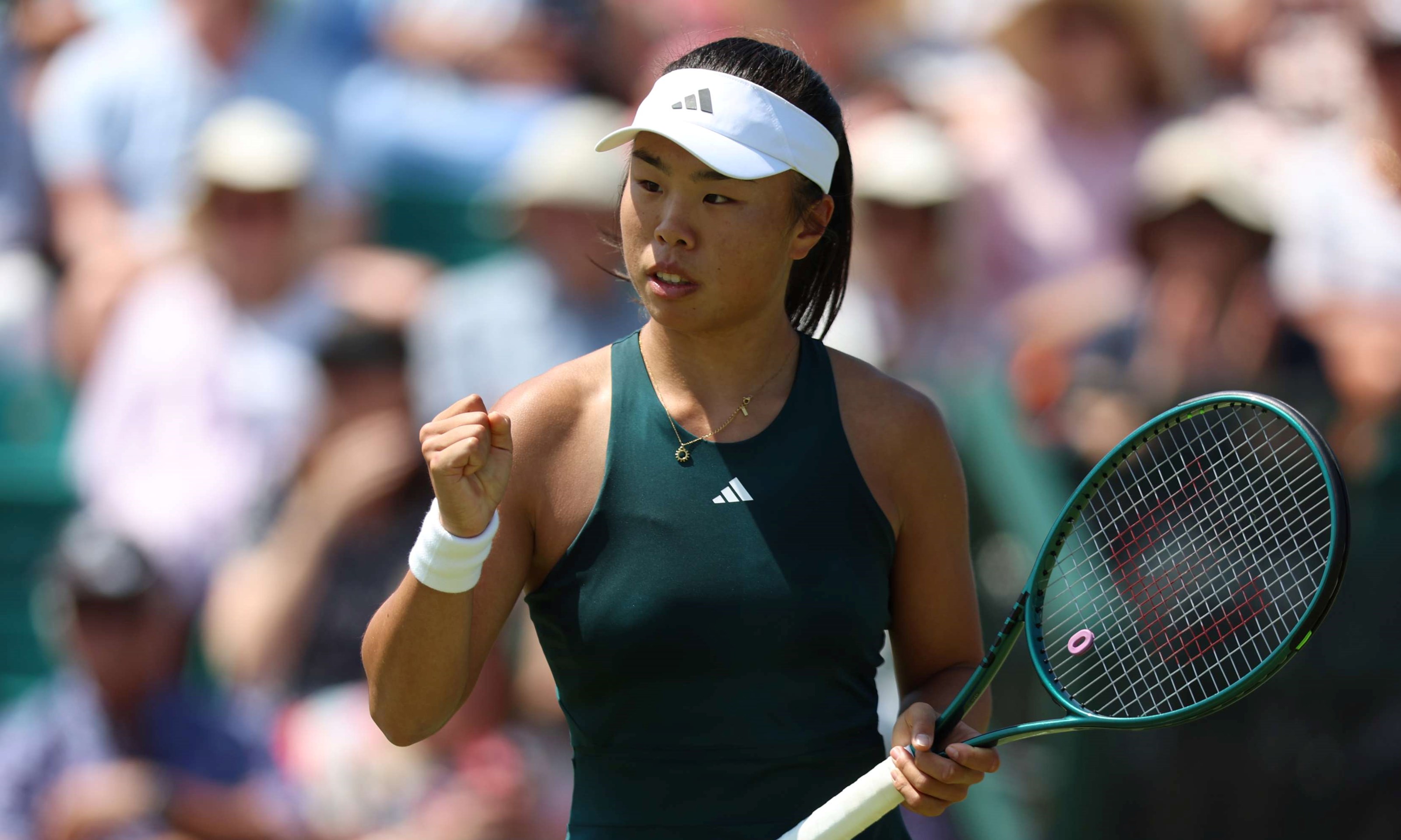 British tennis player, Mimi Xu clenching her fist on court at the Lexus Nottingham Open while holding her tennis racket in her other hand 