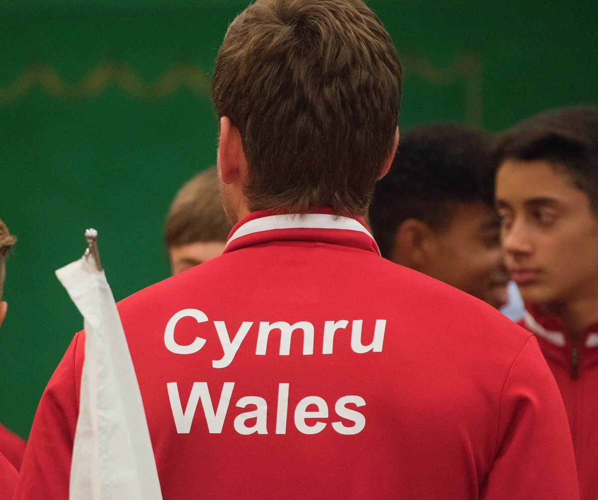 A Tennis Wales official chatting to a group of young Welsh tennis players