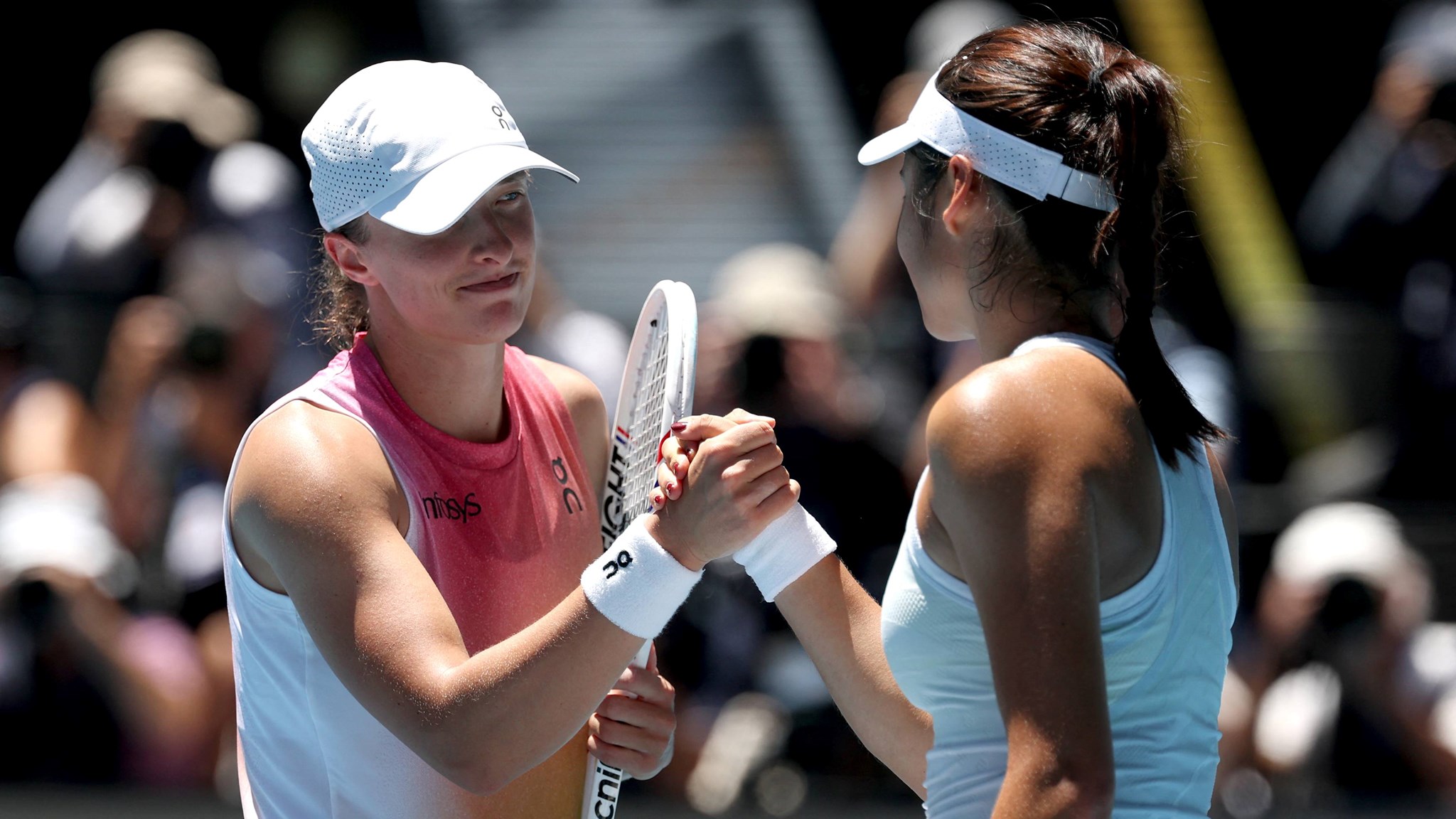 Iga Swiatek and Emma Raducanu shake hands at the Australian Open 2025