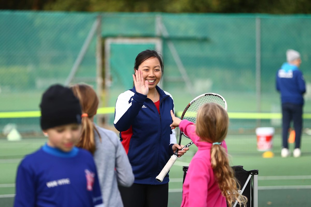 Youth coach high-fiving with young players