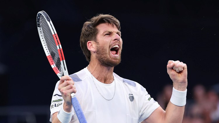 Cam Norrie holding his racket in one hand and clenching his fist in celebration after winning his third round match at the Australian Open