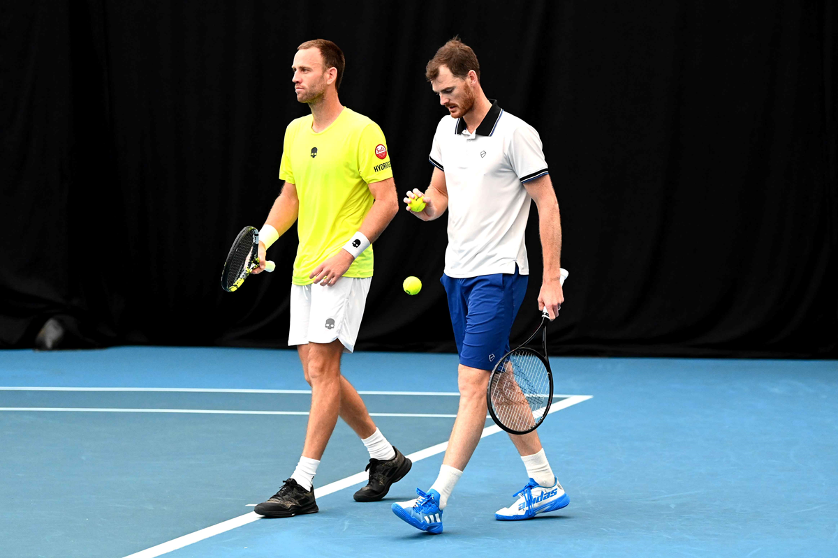 Jamie Murray bouncing tennis balls on court with doubles partner Michael Venus