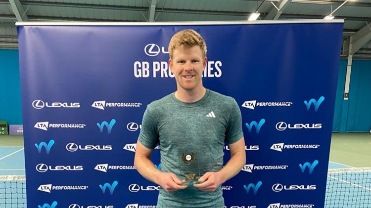 Kyle Edmund holding his M25 Sunderland trophy in front of a Lexus branded background