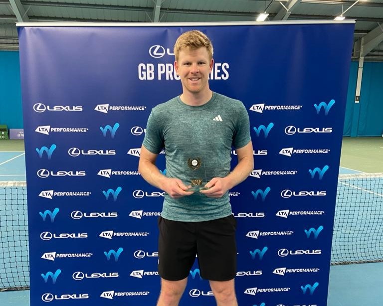 Kyle Edmund holding his M25 Sunderland trophy in front of a Lexus branded background