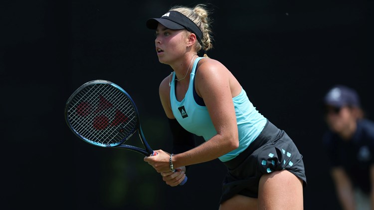 Emily Appleton gripping her tennis racket while preparing to serve on court