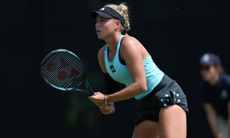 Emily Appleton gripping her tennis racket while preparing to serve on court