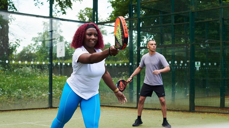 Padel players hitting on court together
