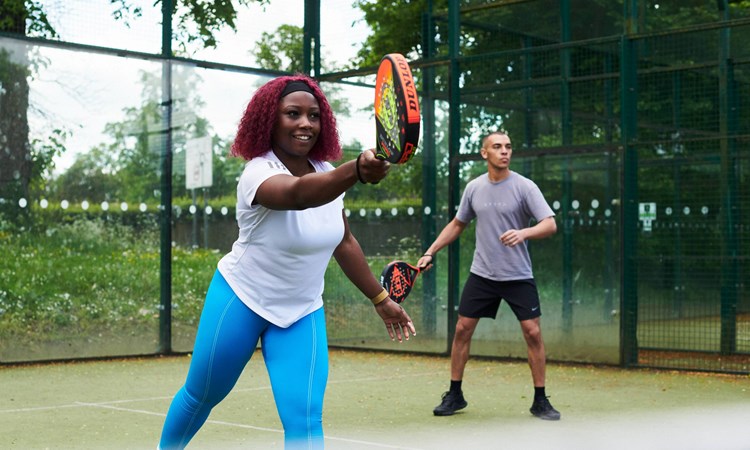 Padel players hitting on court together