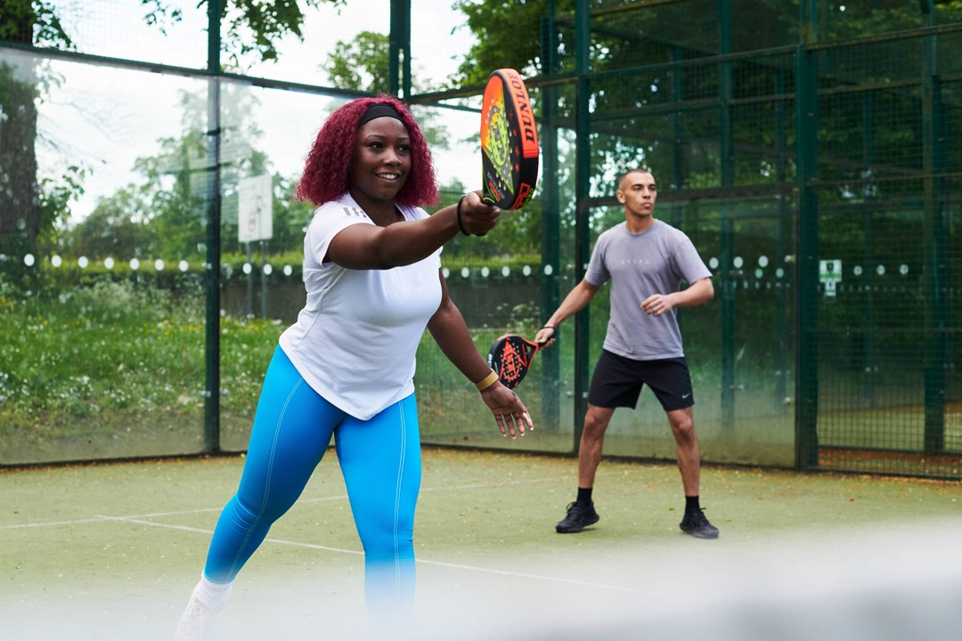 Padel players hitting on court together