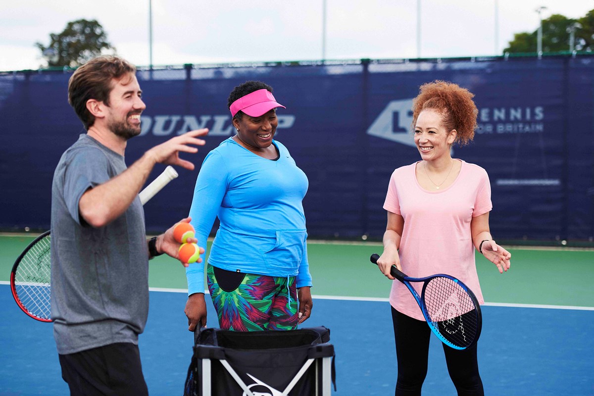 Coach with two adult players on court