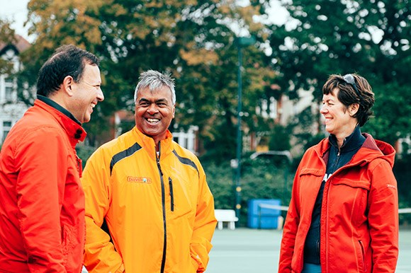 Volunteers laughing with each other on court