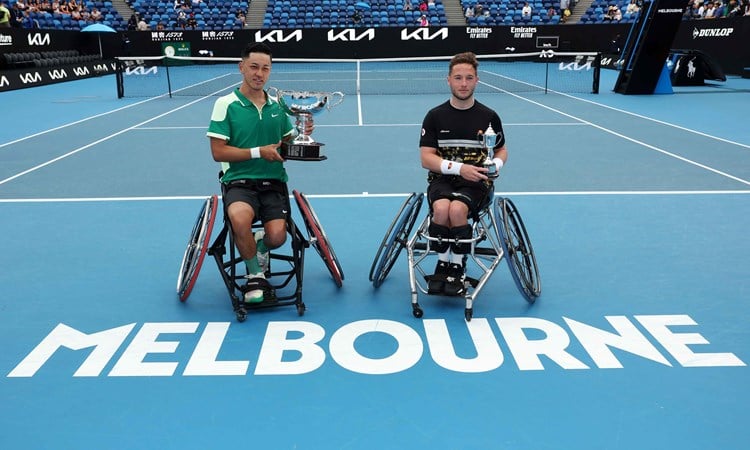 Tokito Oda and Alfie Hewett sat holding their trophies on court at the Australian Open