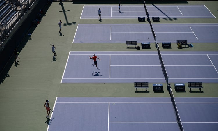 Players practicing across four hard courts at the US Open