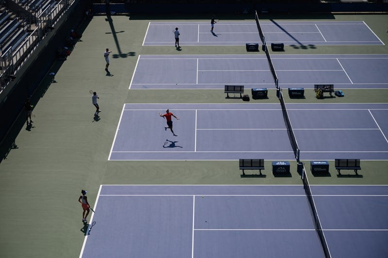 Players practicing across four hard courts at the US Open