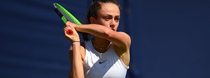 Isabelle Lacy playing a double handed backhand at a tennis tournament