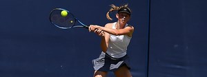 Alicia Dudeney playing a tennis shot at a tournament