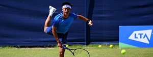 Derrick Chen serving at a tennis tournament