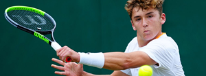 Fabio Nestola playing a slice backhand at a tennis tournament