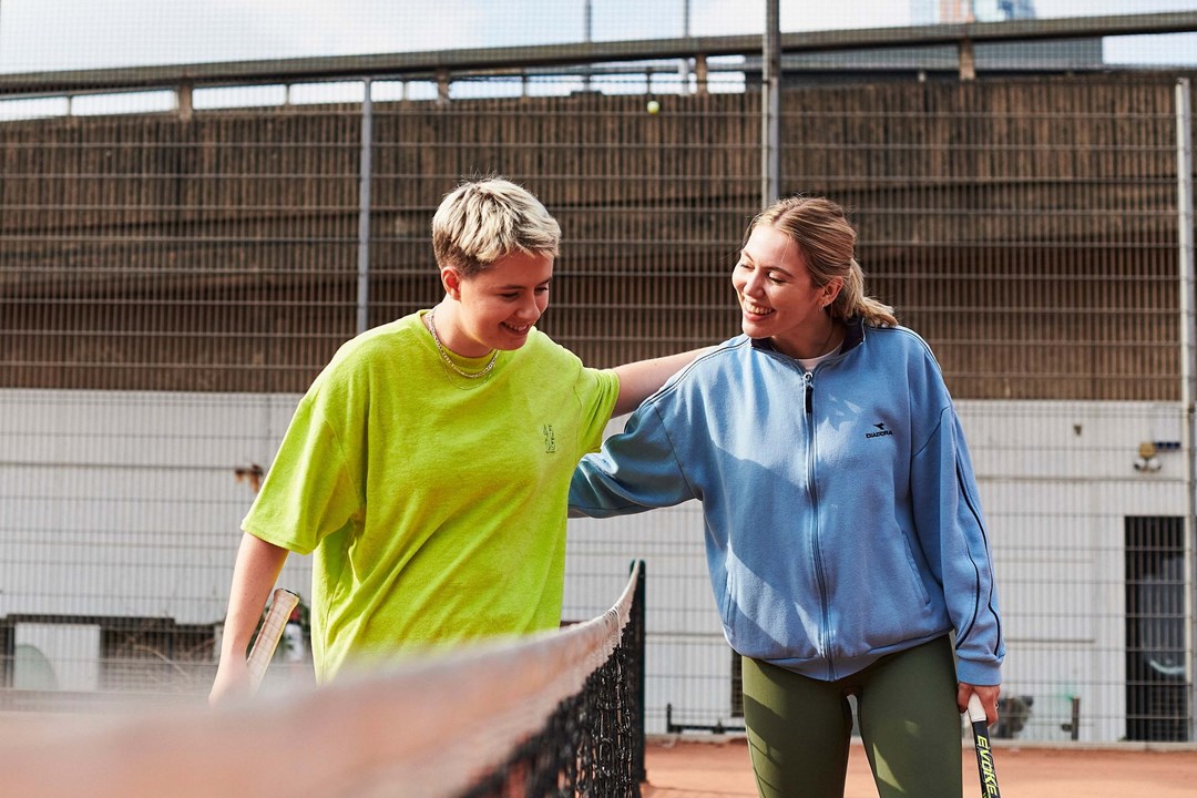 Two women patting each other on the back after a game of tennis