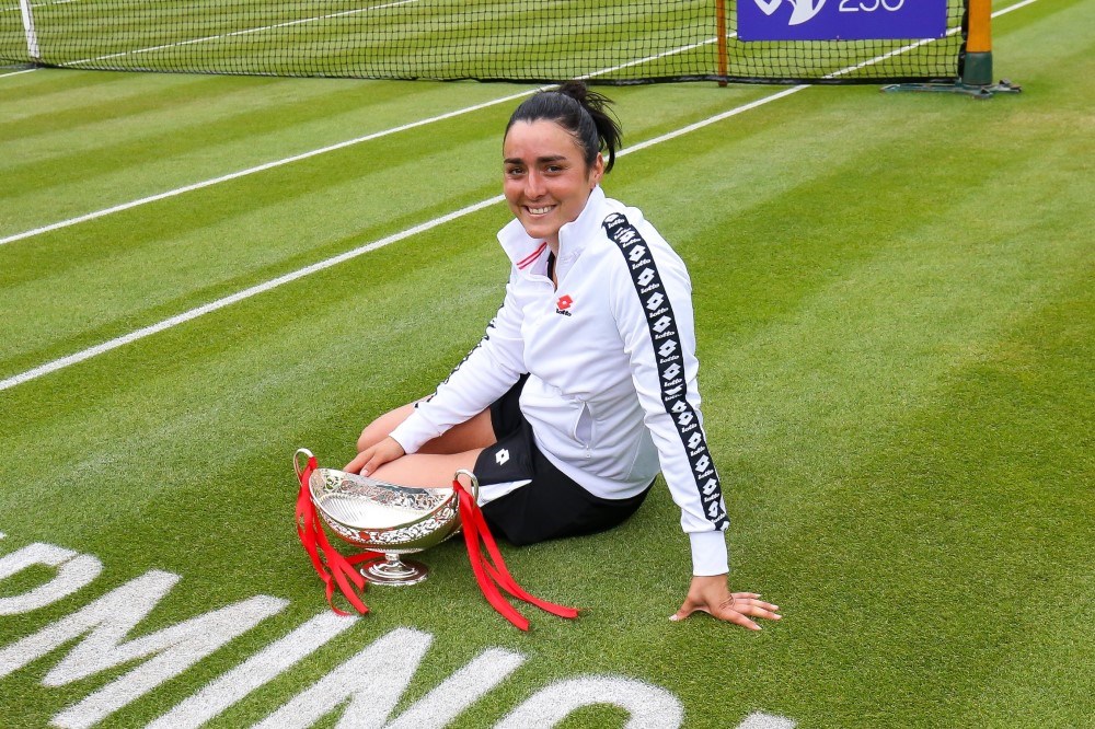 Ons Jabeur, women's champion of the  2021 Birmingham Classic, sitting on court with her trophy. 