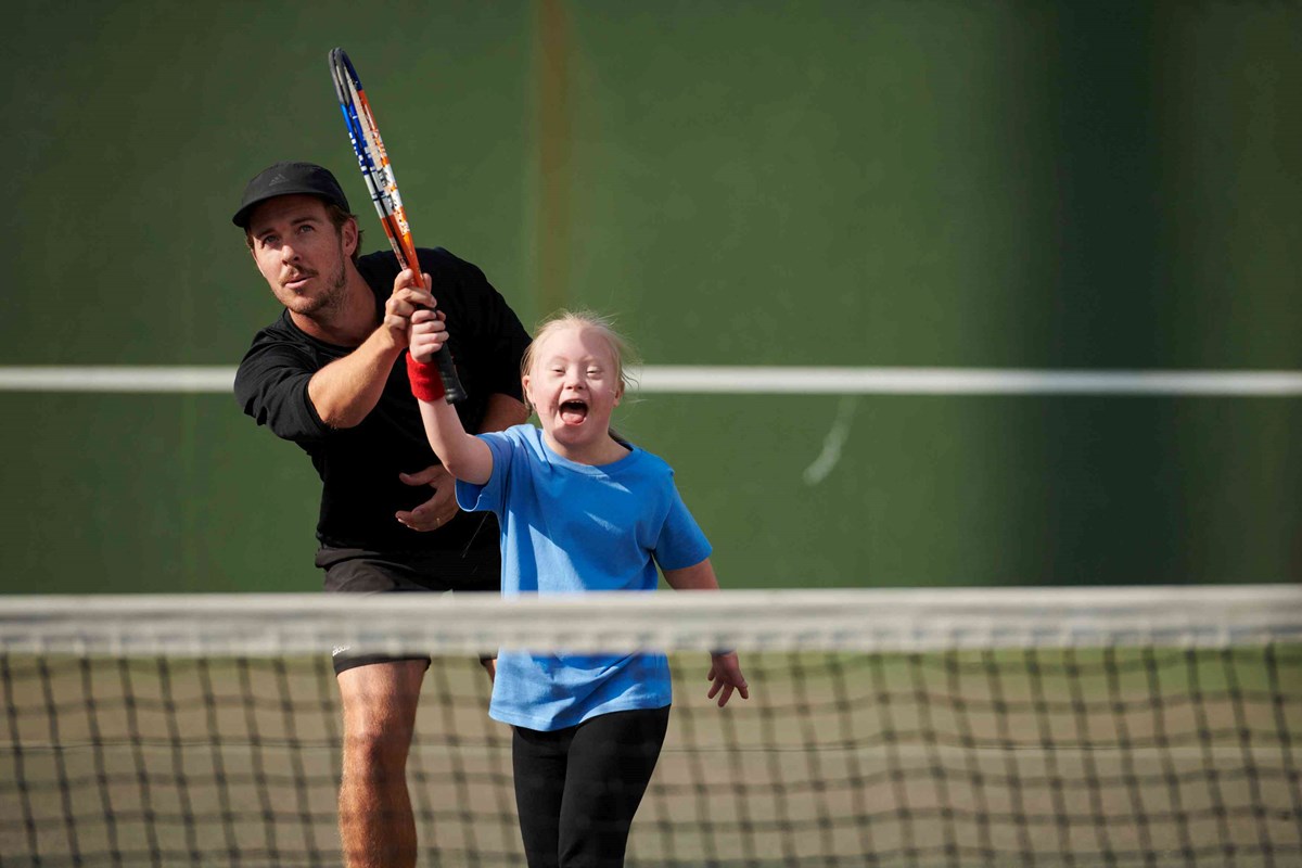 LTA Youth coach helping a kid hit a ball.jpg