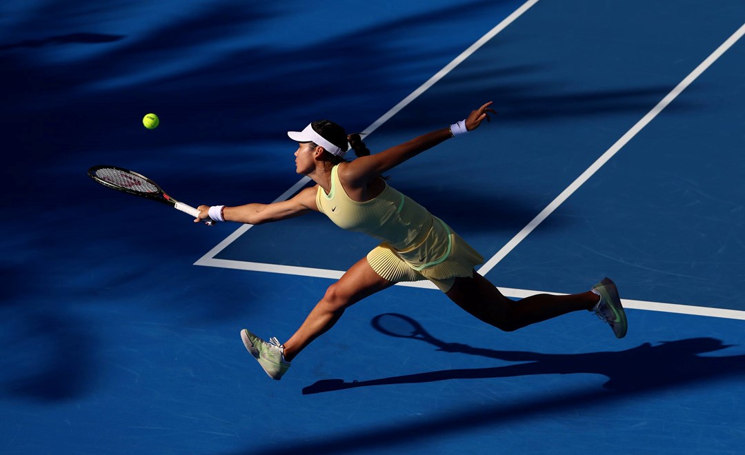 Emma Raducanu stretching to hit a backhand slice on court at the Qatar Open