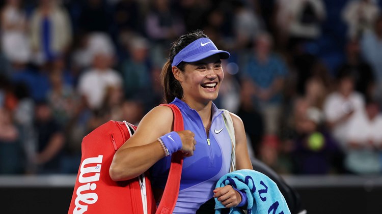 Emma Raducanu smiles walking out on court at the Australian Open