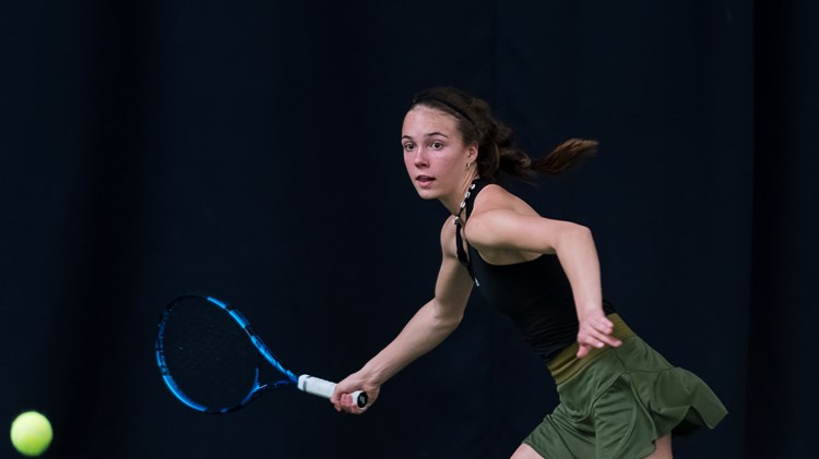 An action shot of British tennis player Hannah Read about to hit a tennis ball.