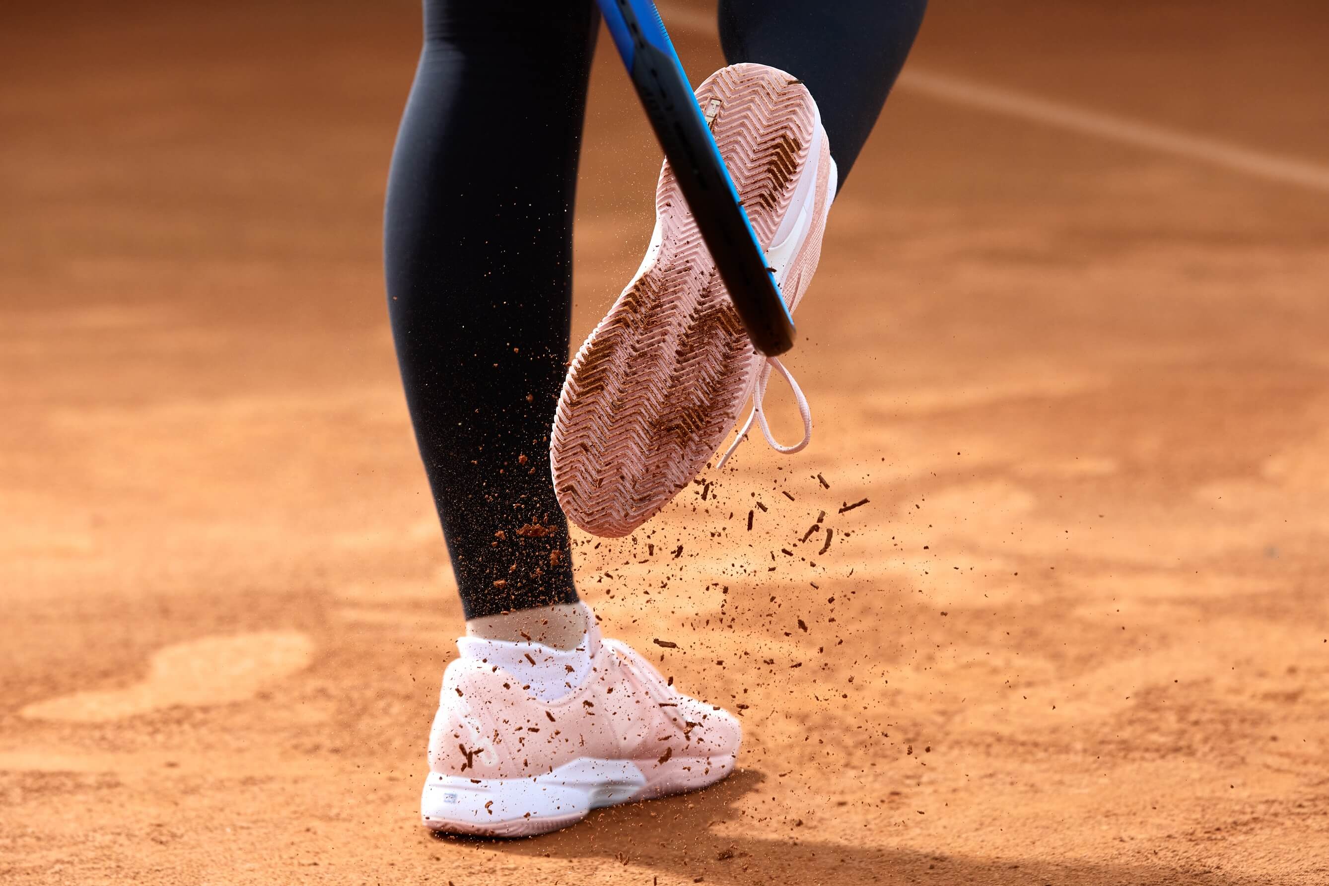 Close-up of tennis player's feet kicking the racket