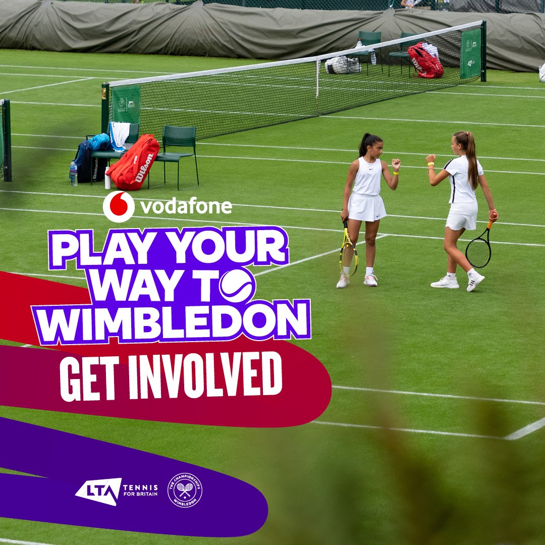 Two young female tennis players fist pumping on a grass court with the Play Your Way to Wimbledon logo superimposed