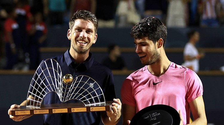 Cam Norrie holding the Rio Open title next to Carlos Alcaraz