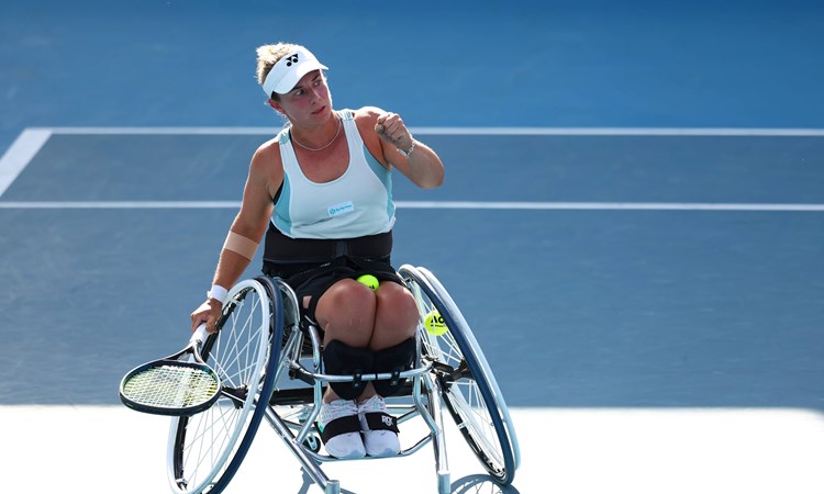 Wheelchair tennis star Lucy Shuker clenching her fist on court while holding her tennis racket