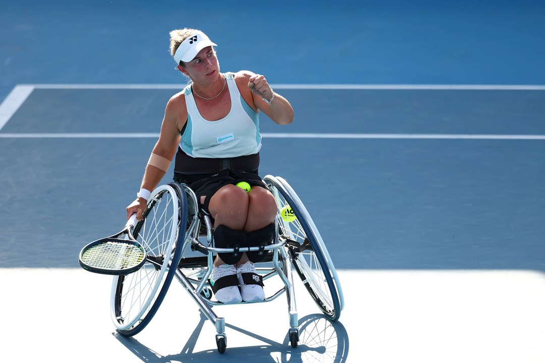 Wheelchair tennis star Lucy Shuker clenching her fist on court while holding her tennis racket