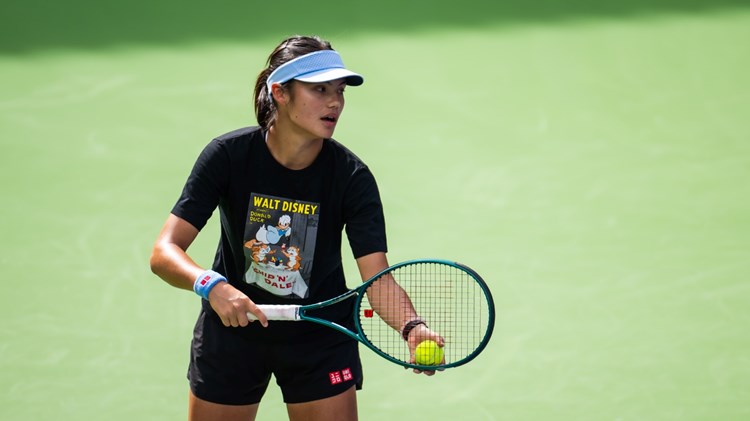 Emma Raducanu holding a tennis racket and ball in her hand while pretending to serve on court at the BNP Paribas Open Indian Wells