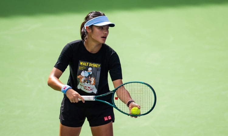 Emma Raducanu holding a tennis racket and ball in her hand while pretending to serve on court at the BNP Paribas Open Indian Wells