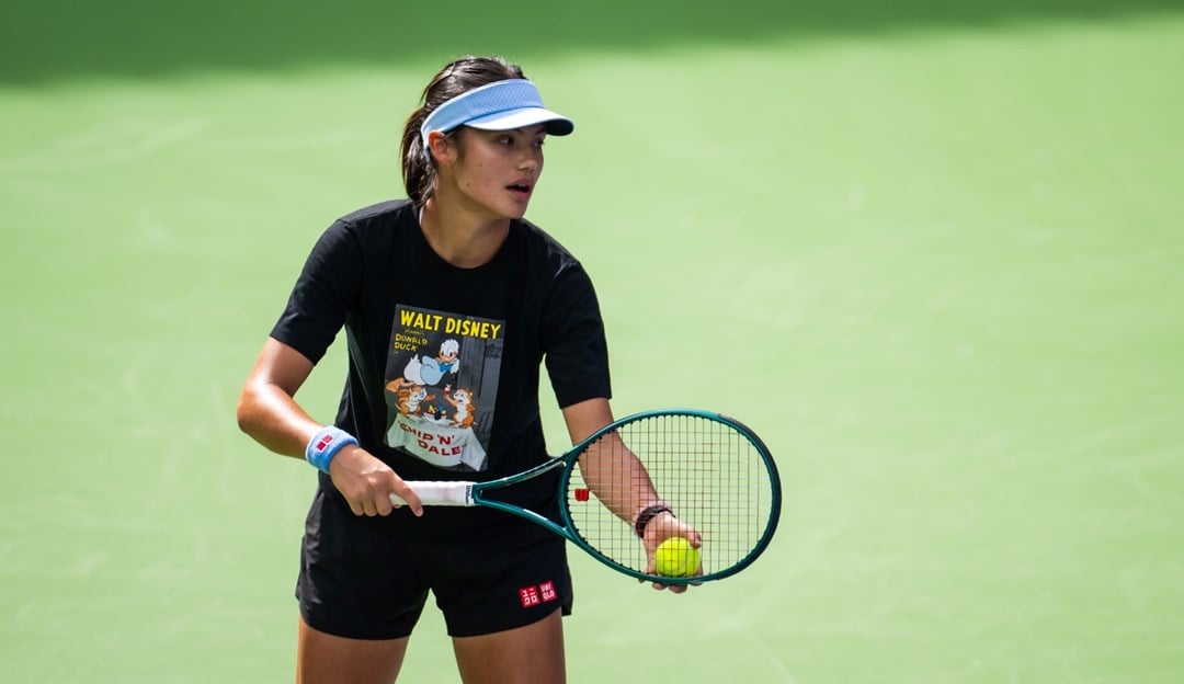 Emma Raducanu holding a tennis racket and ball in her hand while pretending to serve on court at the BNP Paribas Open Indian Wells