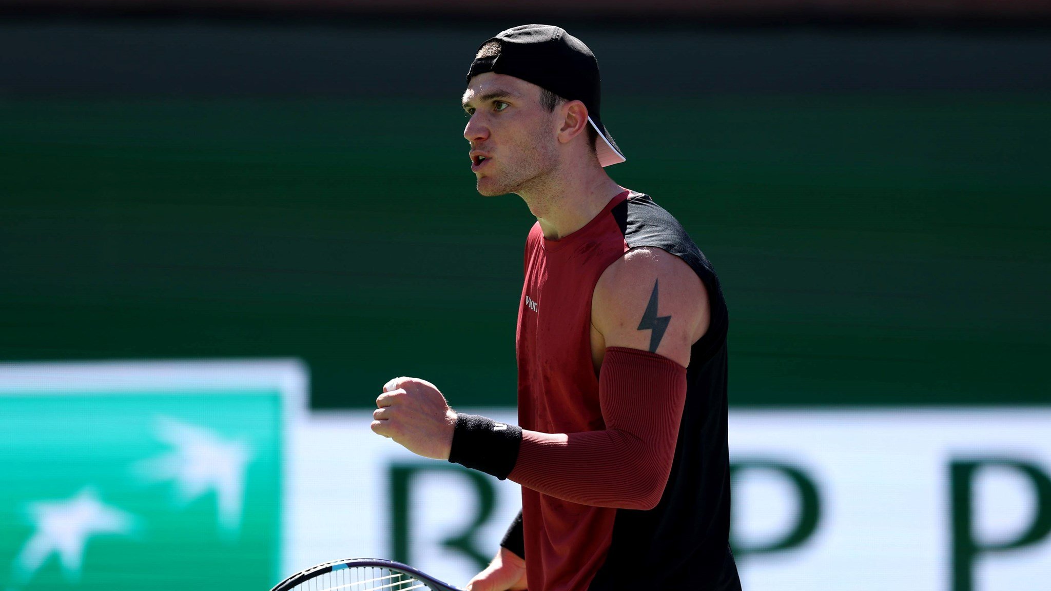 Jack Draper clenching his fist and holding a tennis racket in his other hand while on court at the BNP Paribas Open Indian Wells