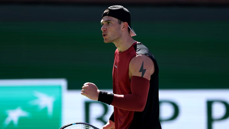 Jack Draper clenching his fist and holding a tennis racket in his other hand while on court at the BNP Paribas Open Indian Wells