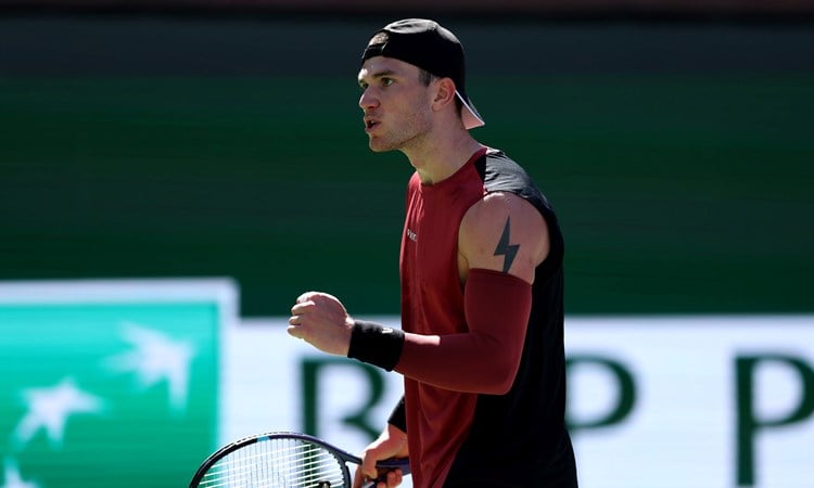 Jack Draper clenching his fist and holding a tennis racket in his other hand while on court at the BNP Paribas Open Indian Wells
