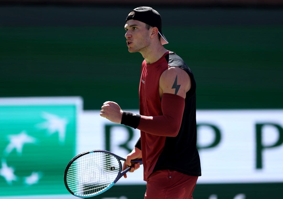 Jack Draper clenching his fist and holding a tennis racket in his other hand while on court at the BNP Paribas Open Indian Wells