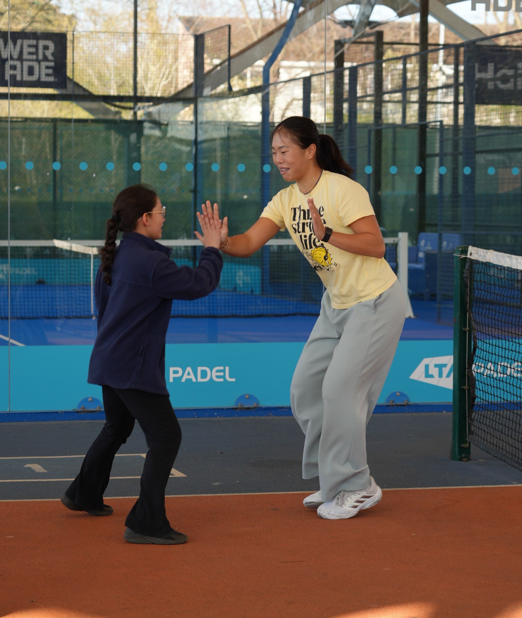 A young girl and an older girl high five
