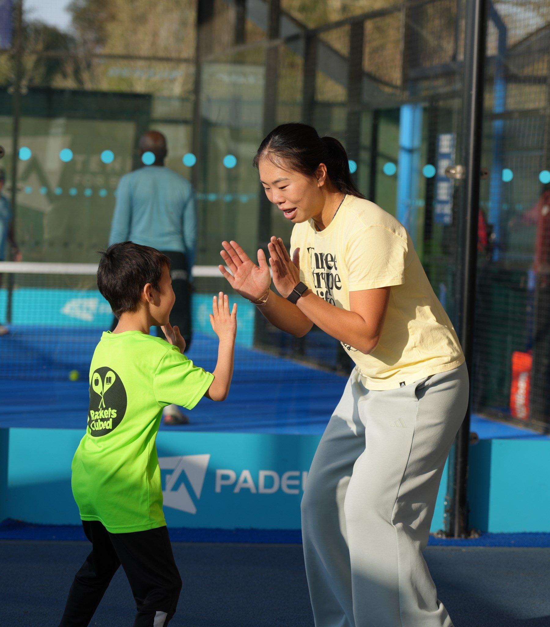 A young boy and an older girl clap hands as part of an activity