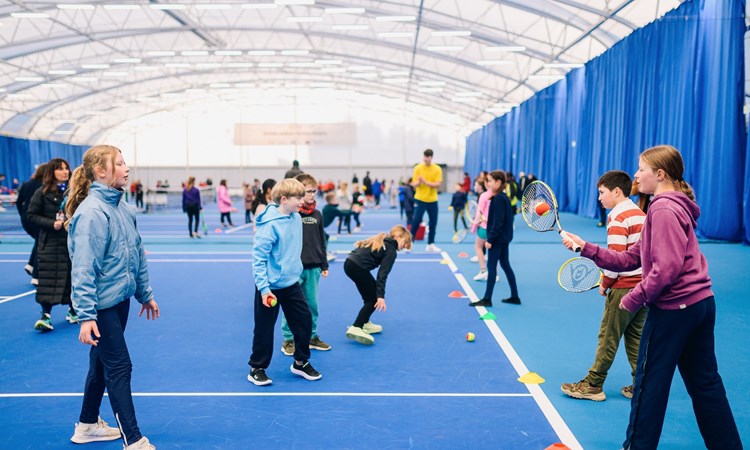 children practicing hitting a ball with a racket
