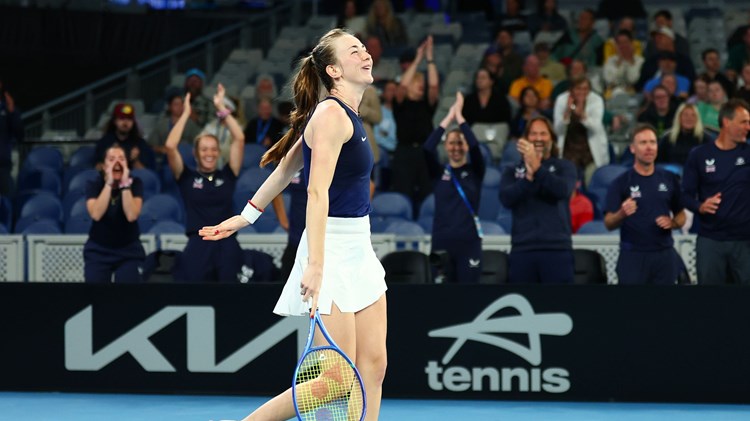 Mika Stojsavljevic smiling on court while holding her tennis racket after winning her first Billie Jean King Cup match on debut